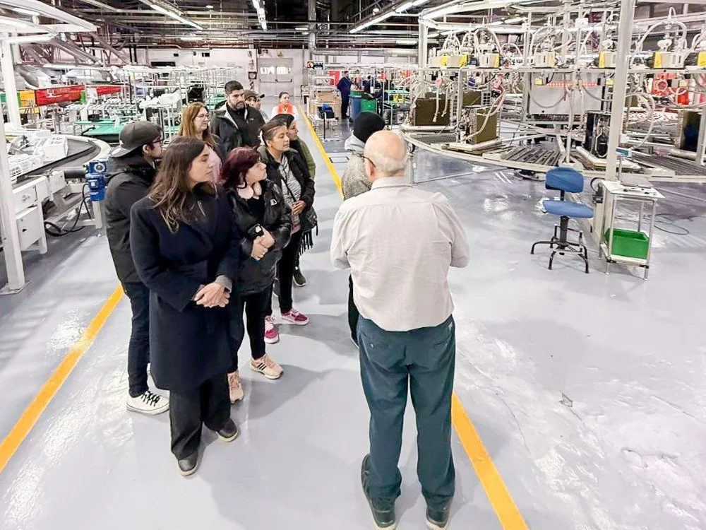 Grupo de personas con casco y chaleco visitando una planta industrial en Río Grande