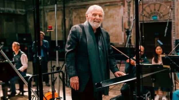 Anthony Hopkins en estudio de grabación con partitura y orquesta de fondo