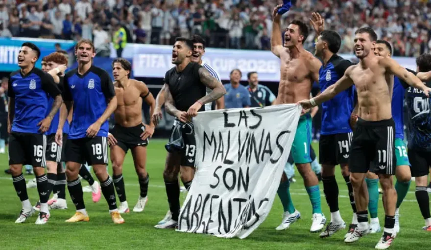 Jugadores de la Selección Argentina sosteniendo una pancarta con la leyenda Las Malvinas son Argentinas en el campo de juego