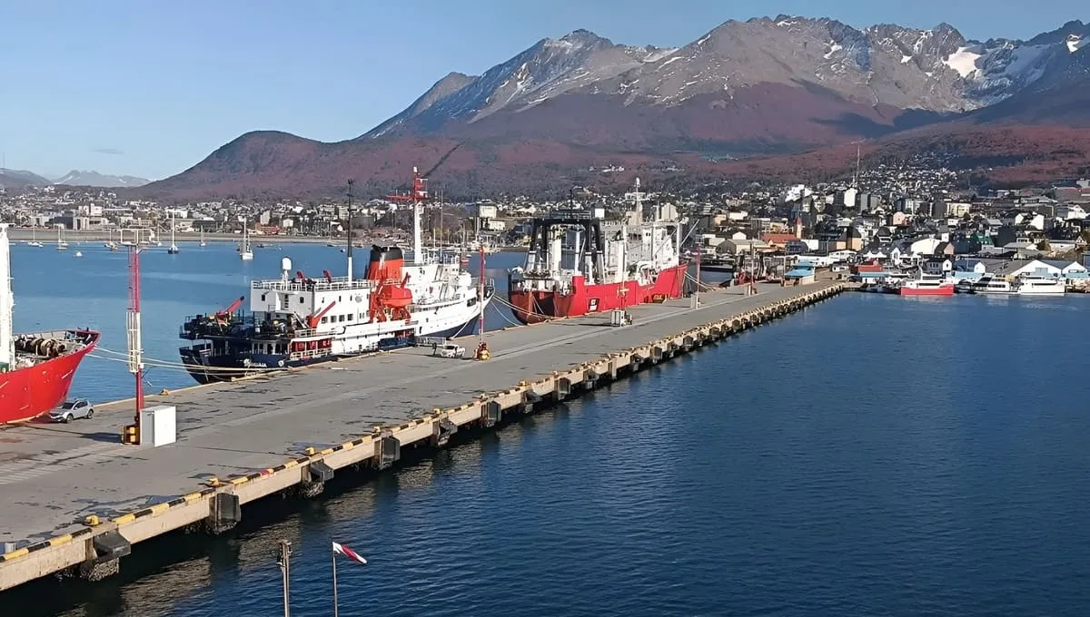 Grupo de trabajadores portuarios reunidos frente a las instalaciones del Puerto de Ushuaia con carteles de reclamo