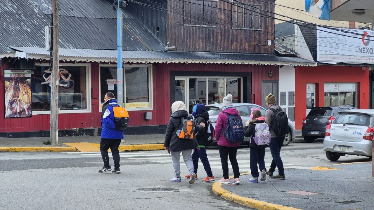 Turistas con ropa de nieve caminando frente al Cerro Castor en Ushuaia con poca concurrencia