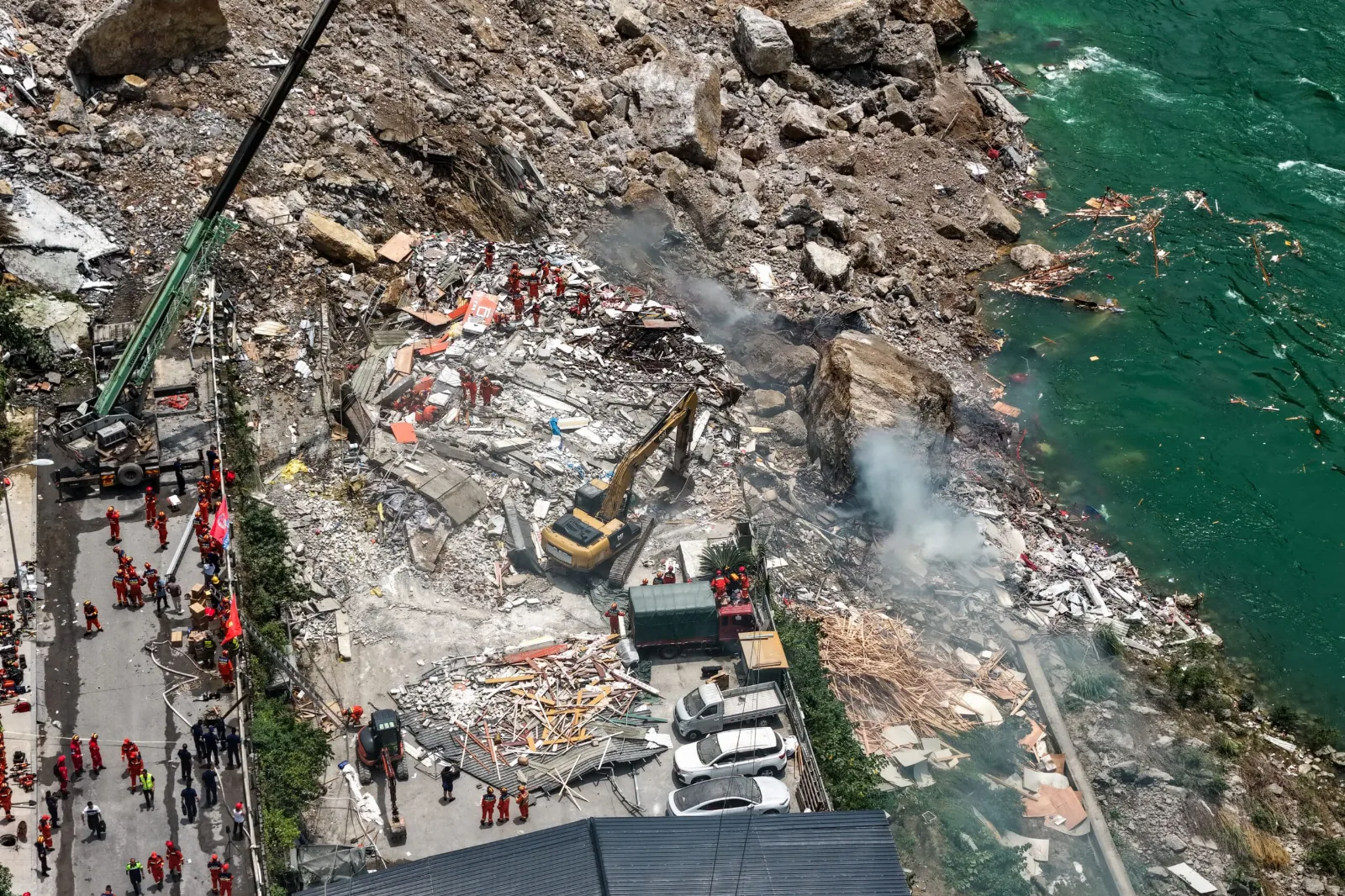 Montaña colapsada con escombros y equipos de rescate trabajando en el lugar