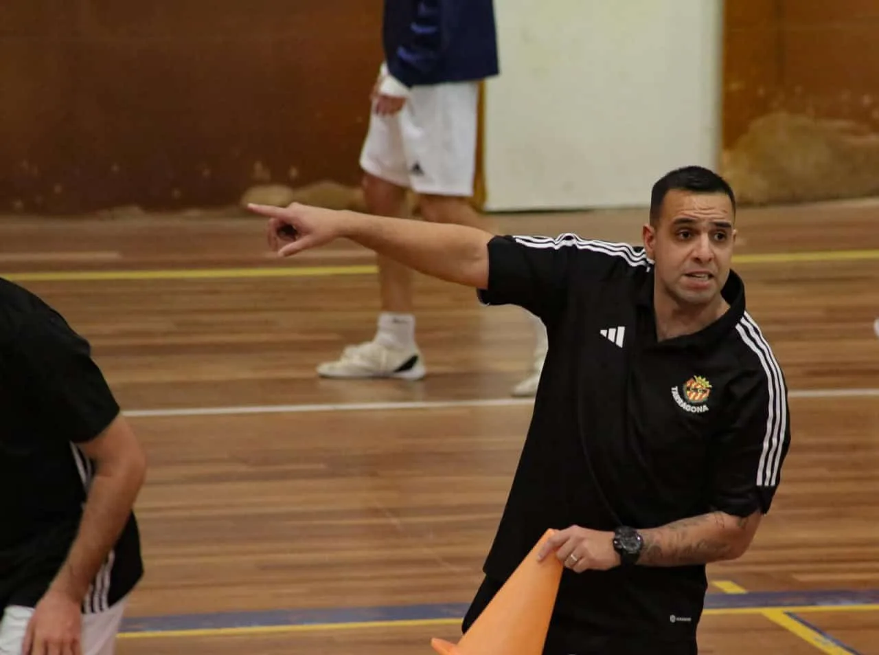 Entrenadores y jugadores de futsal durante una charla de capacitación física en gimnasio fueguino