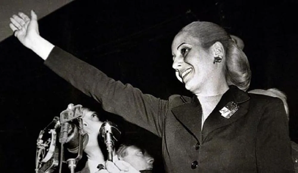 Retrato histórico de Eva Perón en un mural con la bandera argentina y paisaje fueguino