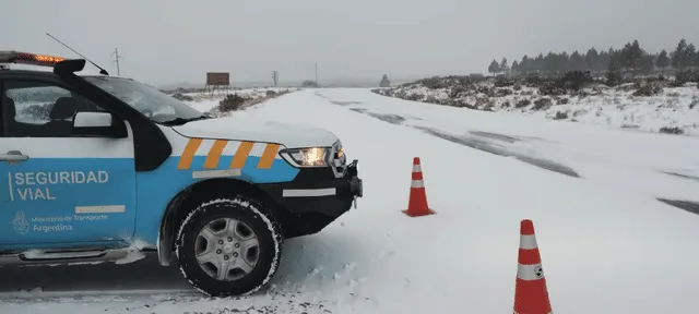 Agentes de tránsito realizando controles de alcoholemia y documentación en una ruta nevada de Tierra del Fuego