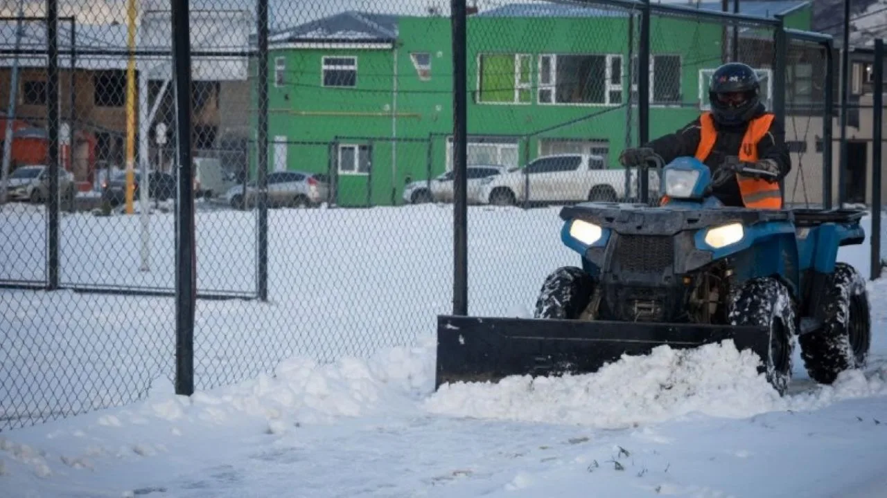 Vereda peatonal en Ushuaia con transeúntes y cordón cordillerano de fondo