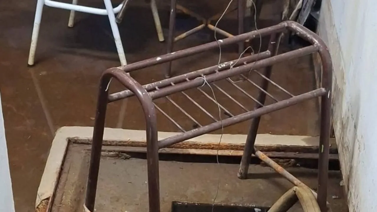 Fachada deteriorada de una escuela fueguina con manchas de humedad y carteles de reclamo
