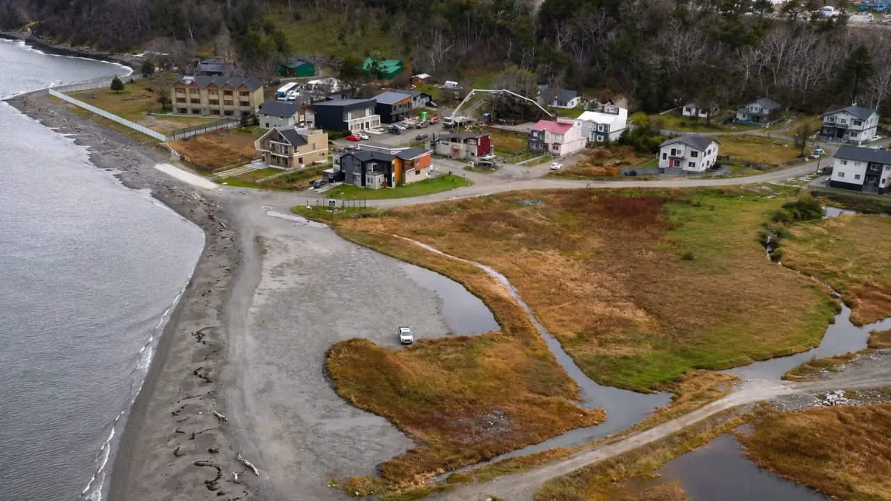 Vista aérea de la costa de Ushuaia con bosques y montañas de fondo, destacando la zona que será Reserva Yámanas
