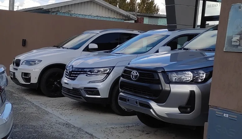 Oficina de Aduana con formularios de importación y automóviles en fondo