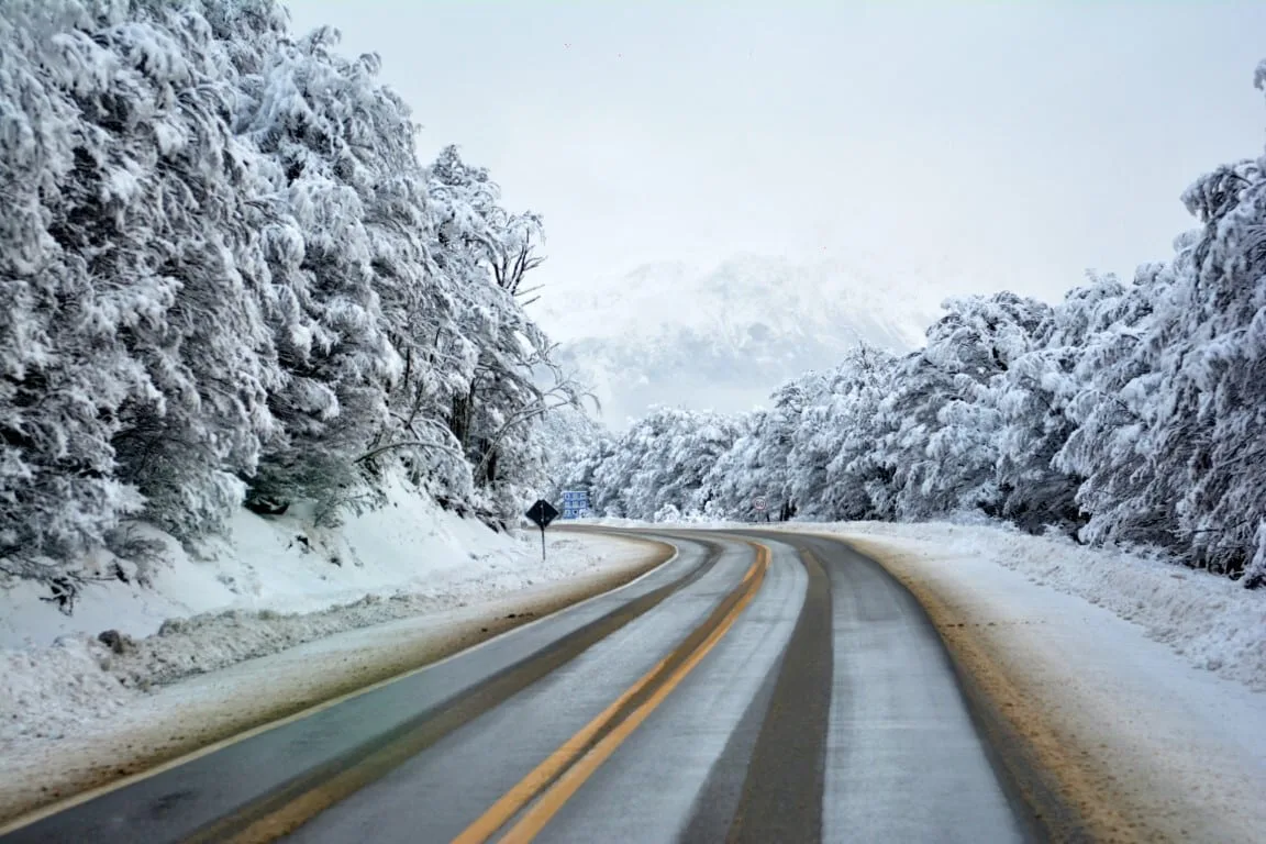 Automóvil circulando con precaución en ruta nevada de Tierra del Fuego