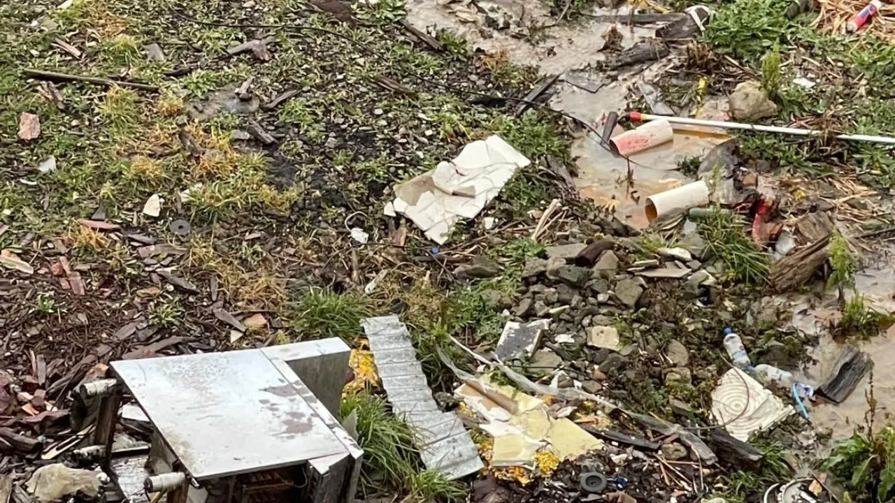 Patio interno lleno de basura, bolsas rotas y charcos de aguas servidas en Ushuaia