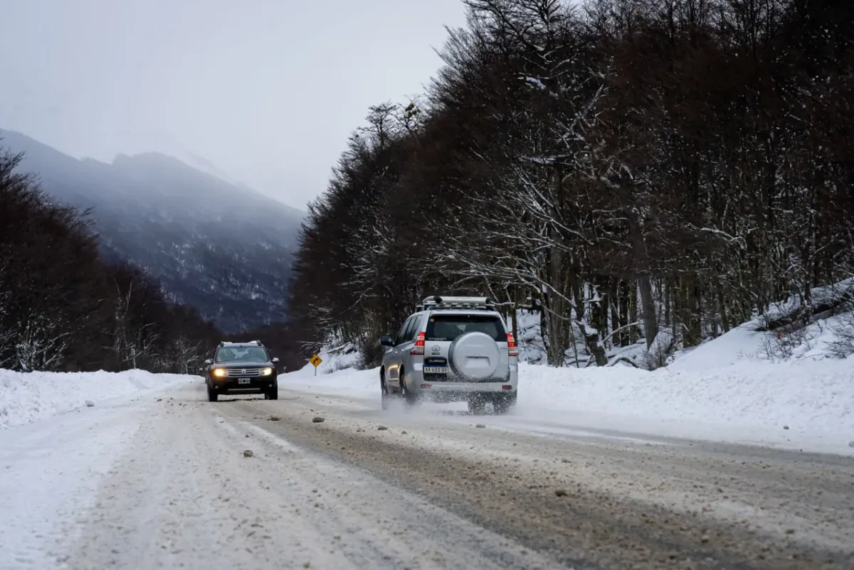 Automóvil con cadenas en ruta nevada de Tierra del Fuego bajo intensa nevada