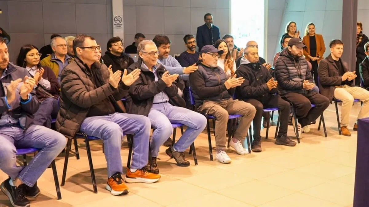 Vecinos reunidos en Chacra VIII junto a maquinaria y postes de luz para la nueva red eléctrica
