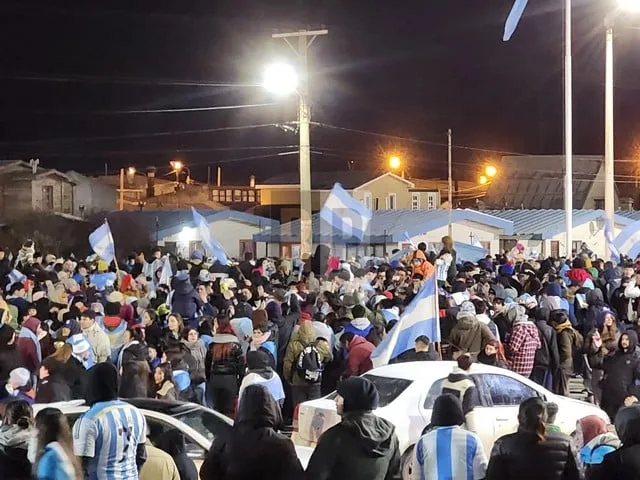 Pantalla de televisión con el partido de Argentina en una casa fueguina, con personas mirando tensas