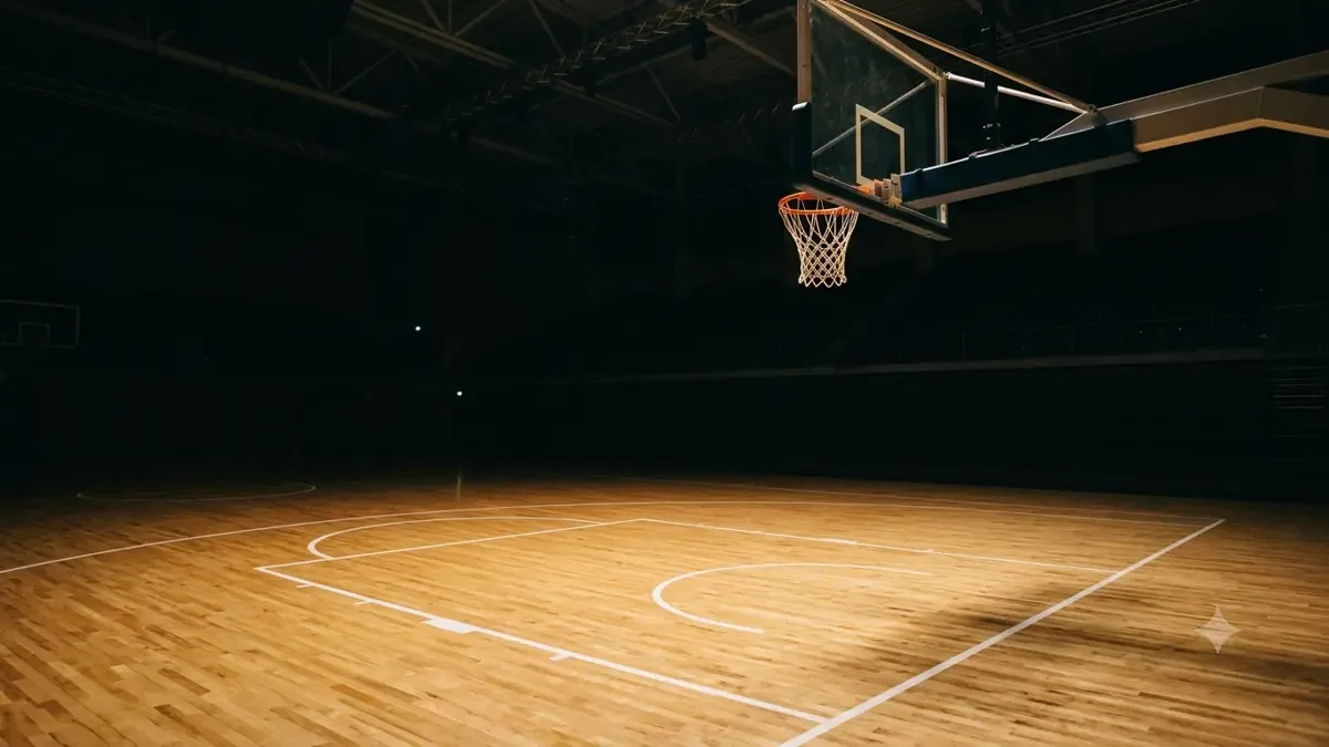 Cancha de básquet de parquet con un aro y red iluminados de noche
