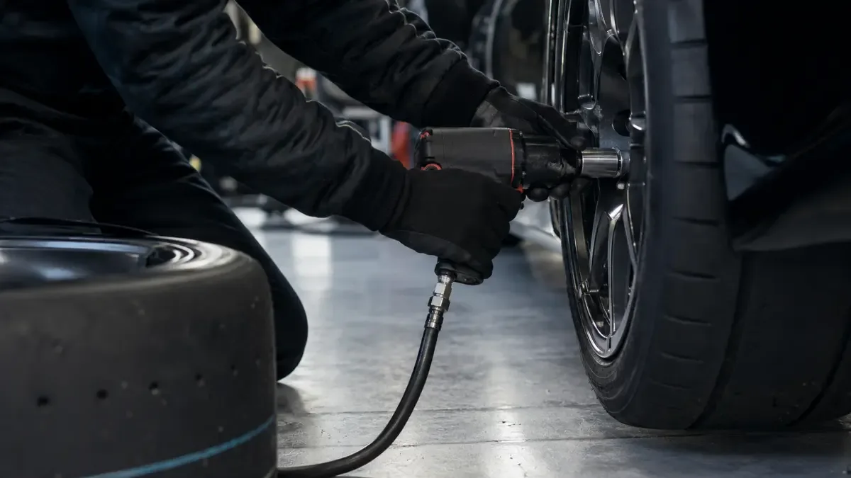 Cambio de neumáticos en los boxes de un autódromo, pistola de impacto y cubierta nueva